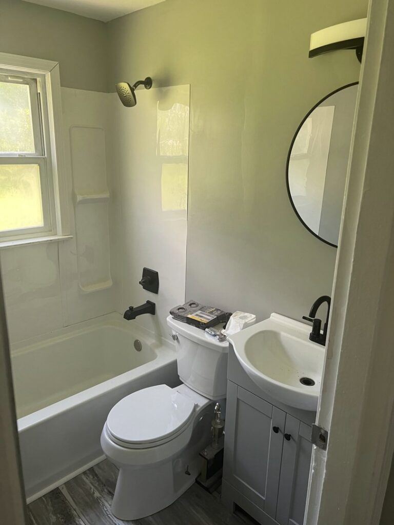A newly completed bathroom remodel featuring a white tub, modern vanity, and new fixtures by Jarrett's Home Improvements & Maintenance Services in Columbus, OH