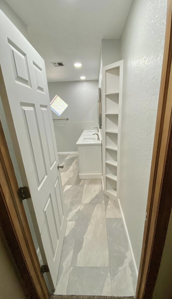 A completed bathroom remodel viewed from the doorway, showing new fixtures and flooring by Cutting Edge Carpentry & Construction in Lawton, OK.