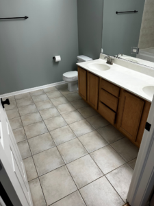 A completed bathroom renovation with a double sink vanity and tiled floor by All In Service Group, LLC in Chicago, IL.