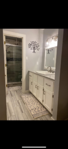 A beautifully completed bathroom renovation with a new vanity, sink, and tiled shower by EJL Construction, LLC in Roswell, NM.