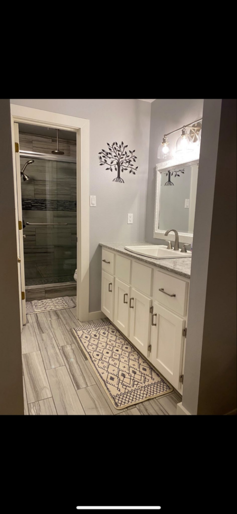 A beautifully completed bathroom renovation with a new vanity, sink, and tiled shower by EJL Construction, LLC in Roswell, NM.