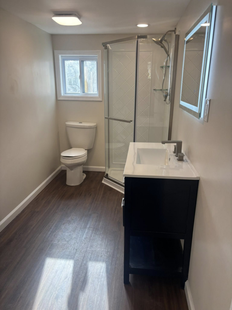 A full view of a completed bathroom renovation with new shower, toilet, and vanity by Fox Renovations in Knoxville, TN