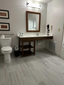 A newly completed bathroom renovation featuring a modern vanity, toilet, and tiled floor by Jay's Construction in Cincinnati, OH.