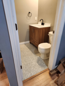A completed bathroom renovation featuring new vanity, toilet, and tile floor by SG Service, LLC in Lincoln, NE