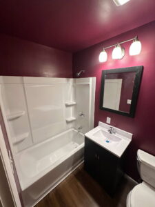 A newly renovated bathroom with a new tub, vanity, and mirror completed by Urban Restoration, LLC in Indianapolis, IN