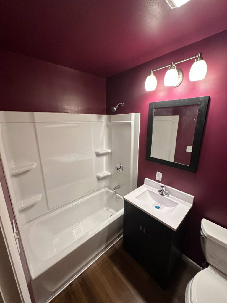 A newly renovated bathroom with a new tub, vanity, and mirror completed by Urban Restoration, LLC in Indianapolis, IN