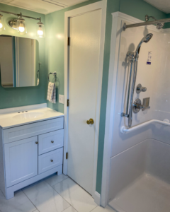 A completed bathroom renovation featuring a new vanity, mirror, lighting, and walk-in shower by Yellow Ladder Contracting in Mount Pleasant, SC