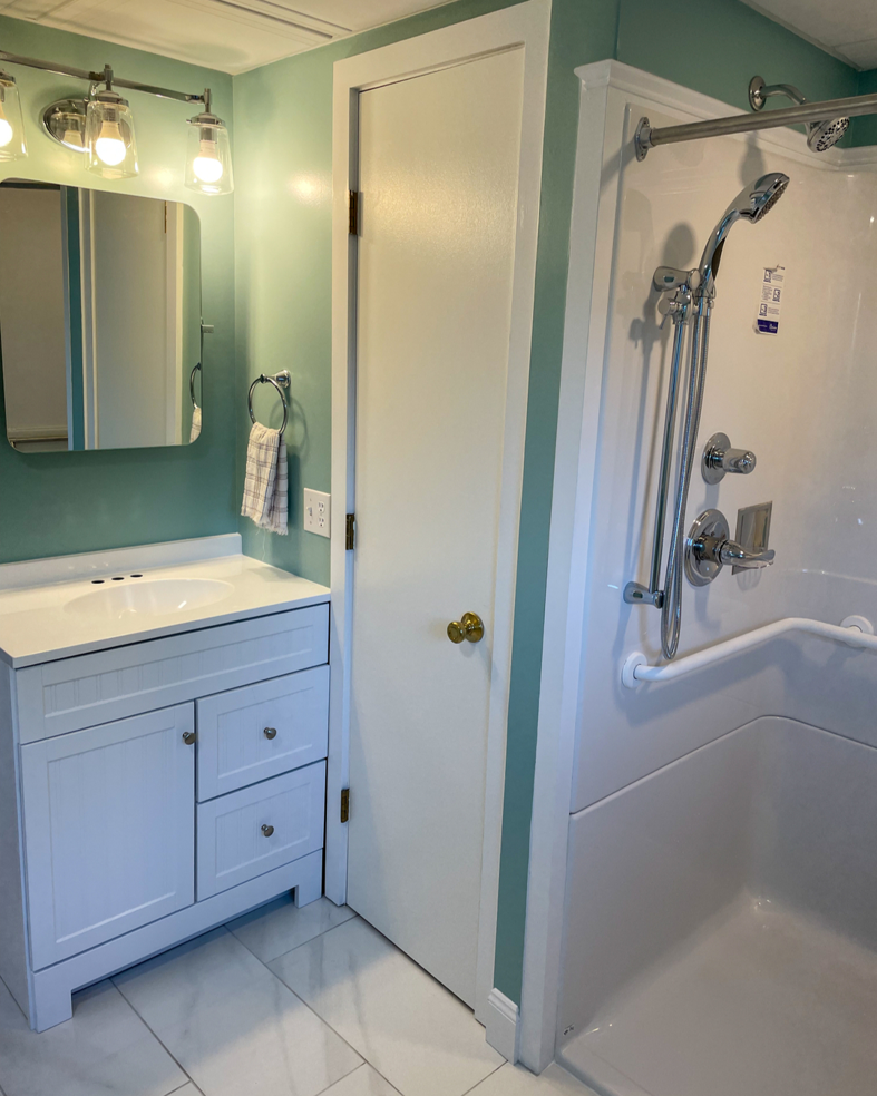 A completed bathroom renovation featuring a new vanity, mirror, lighting, and walk-in shower by Yellow Ladder Contracting in Mount Pleasant, SC