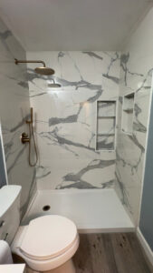 A completed bathroom shower and toilet area remodel with new tiles and flooring by Castillejo Handyman Services in San Diego, CA