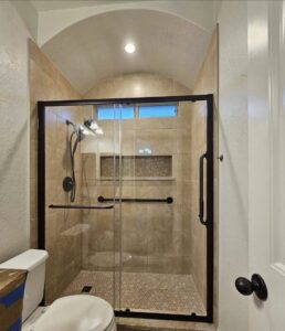 A completed bathroom featuring a tiled shower with a glass door and modern fixtures by TEXAN Home Improvements LLC in San Antonio, TX.