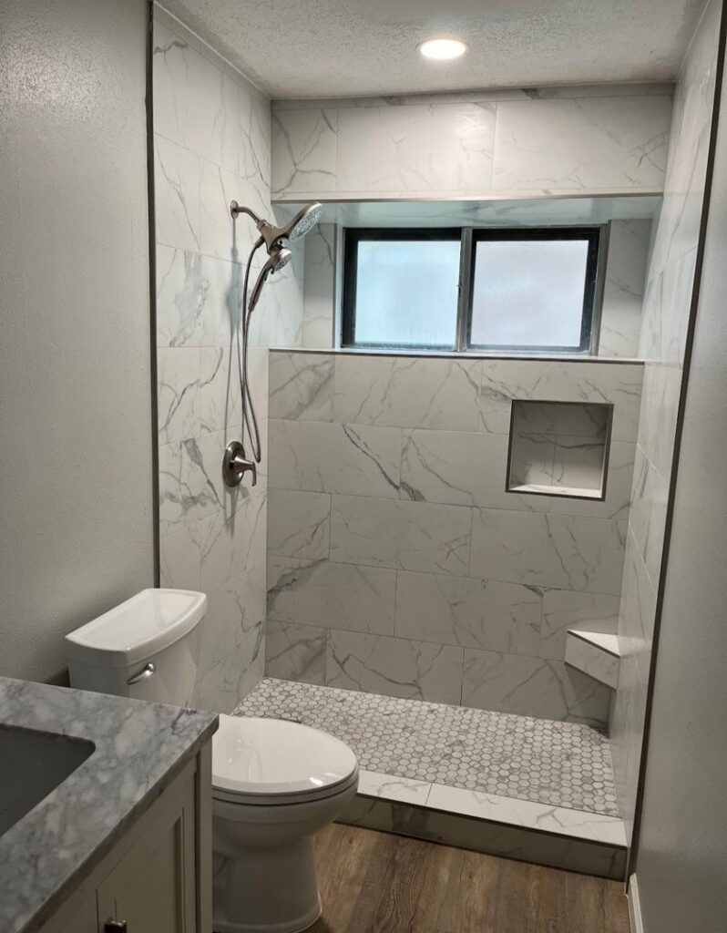 A newly completed bathroom featuring a modern tiled shower and toilet by TEXAN Home Improvements LLC in San Antonio, TX.
