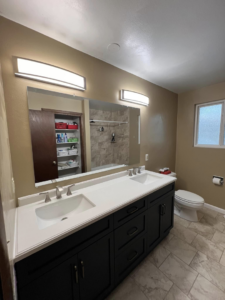 A newly completed bathroom featuring a double vanity, large mirror, and modern light fixtures by JP Handyman Wyo in Sheridan, WY