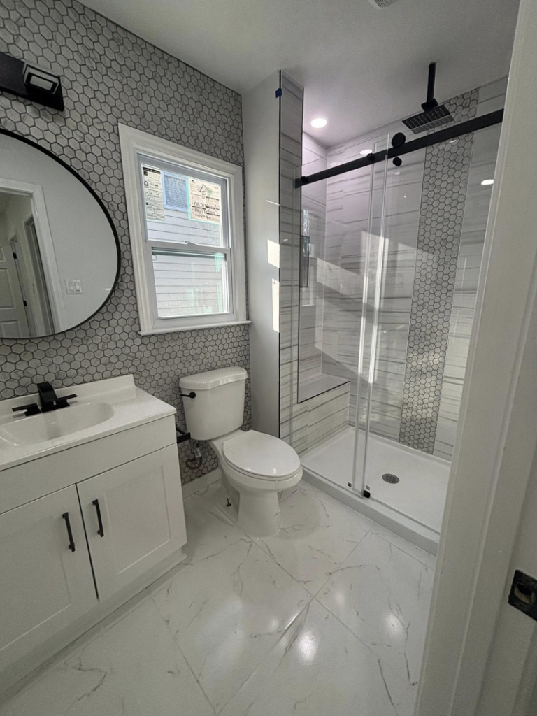 A completed modern bathroom remodel showcasing a new vanity, sink, and mirror installed by JJConstruction203 LLC in Charlotte, NC.