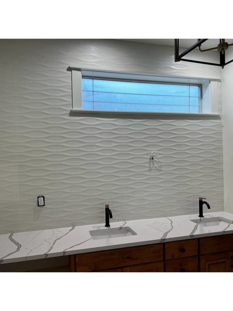 A completed bathroom vanity and textured tile wall installation by Tom Broglia Building & Remodeling Services in Boise, ID.