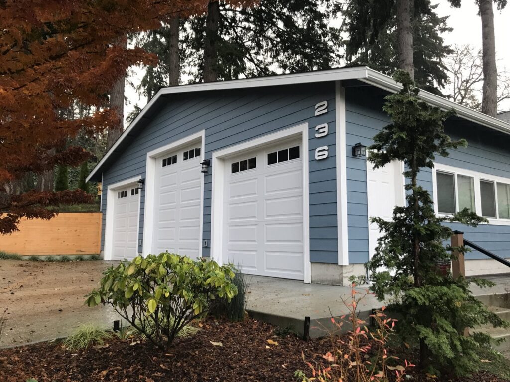 A newly completed garage with blue siding and white garage doors by Garages Etc in Tacoma, WA