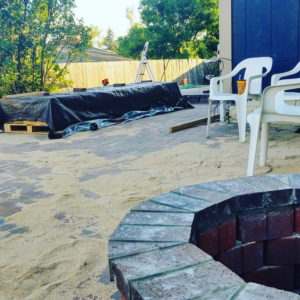 A completed brick fire pit and patio area with sand, a project by Steveson Enterprises, Inc. in Golden, CO.