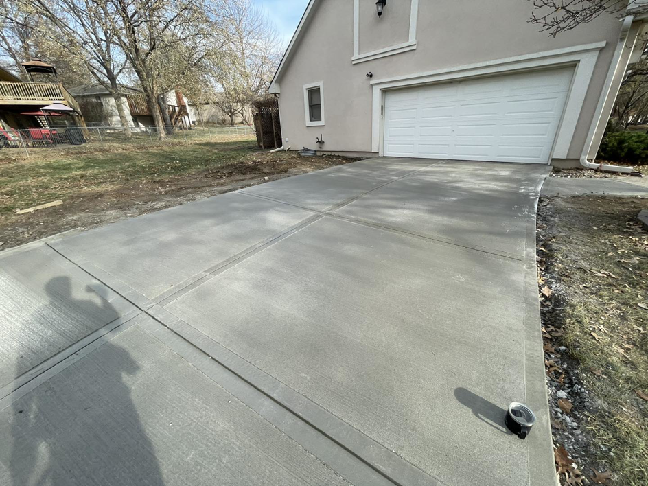 A completed concrete driveway leading to a residential garage, expertly installed by DC's Precision Contracting LLC in Colorado Springs, CO.