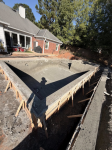 A completed concrete pool shell with surrounding formwork, ready for the next stage by Ga Impact Shotcrete in Atlanta, GA.