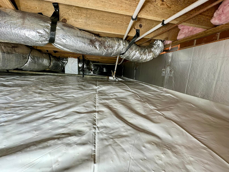 A completed crawlspace sealing project with a clean vapor barrier and insulation by Ramos Waterproofing & Crawlspace Sealing LLC in Durham, NC.