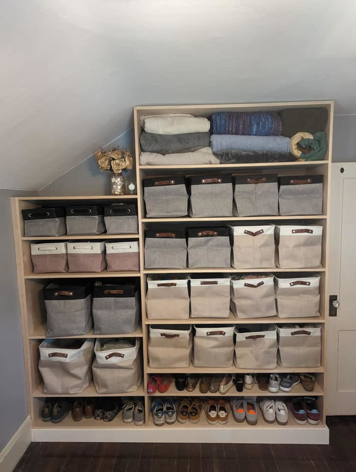 A completed custom wooden shelving unit, organized with bins and shoes, by Friendly Neighborhood Handyman in Uxbridge, MA.