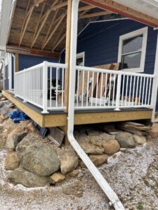 A newly completed deck with white railings and a downspout by S-Squared Construction in Madison, WI.