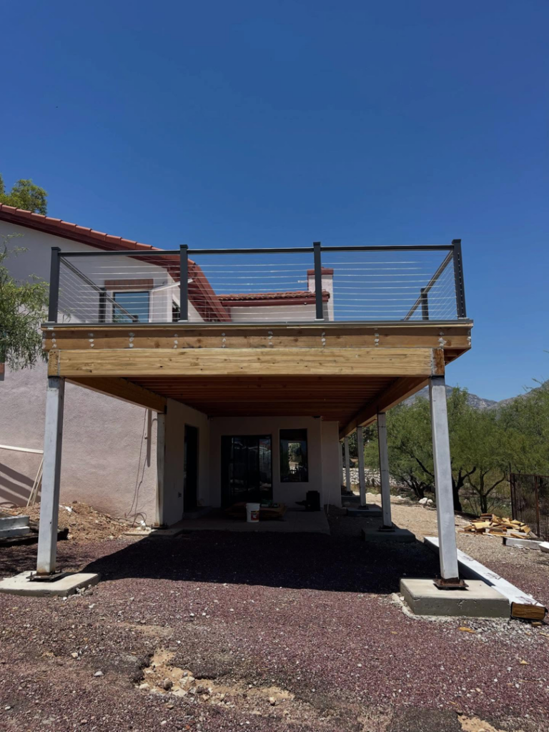 A completed elevated deck with cable railings and support pillars by Raven Construction LLC in Tucson, AZ.