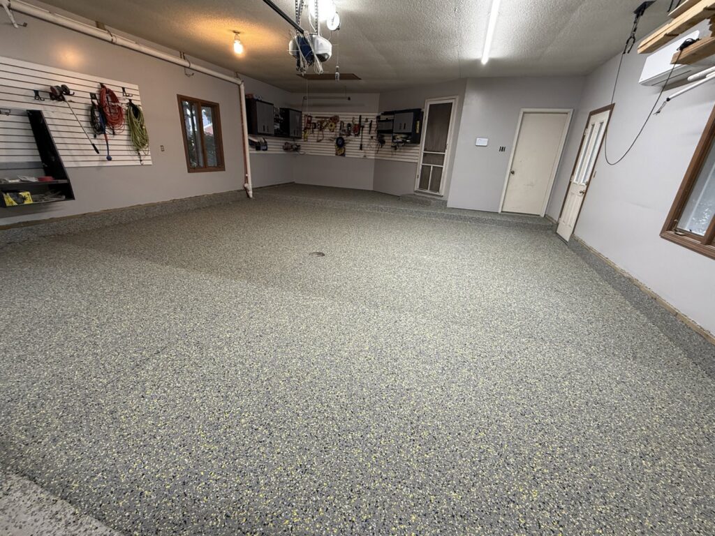 A completed epoxy flake garage floor with organized tools by Premier Edge Concrete in Grand Rapids, MI
