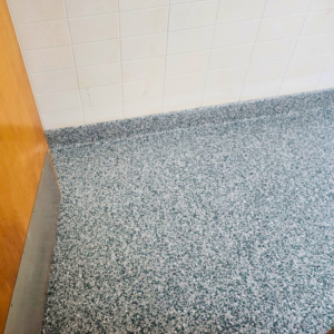 A newly installed speckled epoxy floor in a bathroom by Lifetime Epoxy Floors North Alabama in Boaz, AL.