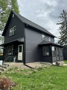 A house with newly installed black siding and roof after a complete exterior renovation by M&V Home Solutions Inc in Elgin, IL