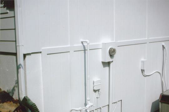 A freshly painted white exterior wall with neatly installed pipes and electrical boxes by AAA Lifetime Exterior & Remodeling LLC in Kansas City, MO.