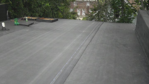 A newly completed flat roof installation with visible seams, a service provided by Camelot Development in Bridgeport, CT.