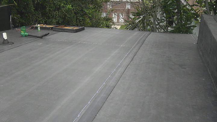A newly completed flat roof installation with visible seams, a service provided by Camelot Development in Bridgeport, CT.