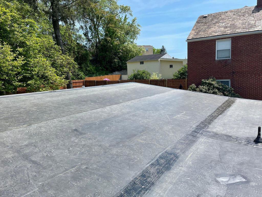 A newly installed flat roof, likely TPO or EPDM, on a commercial or residential building by Prescott Roofing and Masonry in Carnegie, PA.