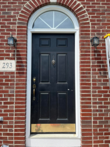 A newly installed and finished black front door with a white frame, showcasing completed work by JB Recovery in Columbus, OH.