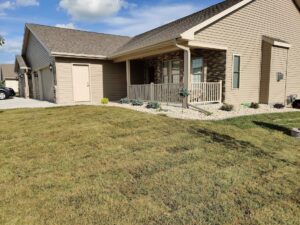 A completed front yard landscaping project featuring gravel and various plants by Wildflower Landscapers LLC in Larsen, WI