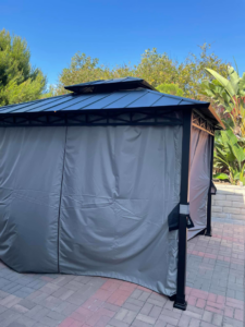 A newly installed gazebo with privacy curtains on a paved patio, showcasing a completed outdoor project by Handyman SanDiego in San Diego, CA.