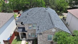 Aerial view of a house with a newly completed gray shingle roof by PaRu Construction LLC in San Antonio, TX