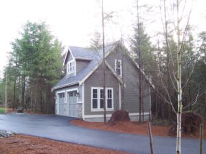 A newly built garage with gray siding and stone accents by Garages Etc in Tacoma, WA