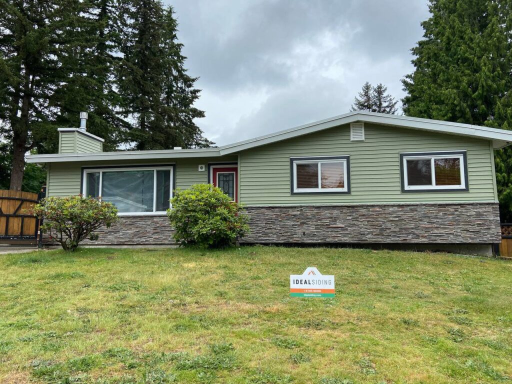 A beautiful light green house with new siding and stone accents, a completed project by Ideal Siding Richmond, VA.