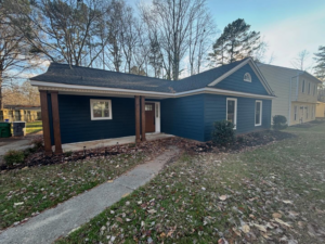 A beautifully completed house exterior remodel with new blue siding and porch columns by JJConstruction203 LLC in Charlotte, NC.