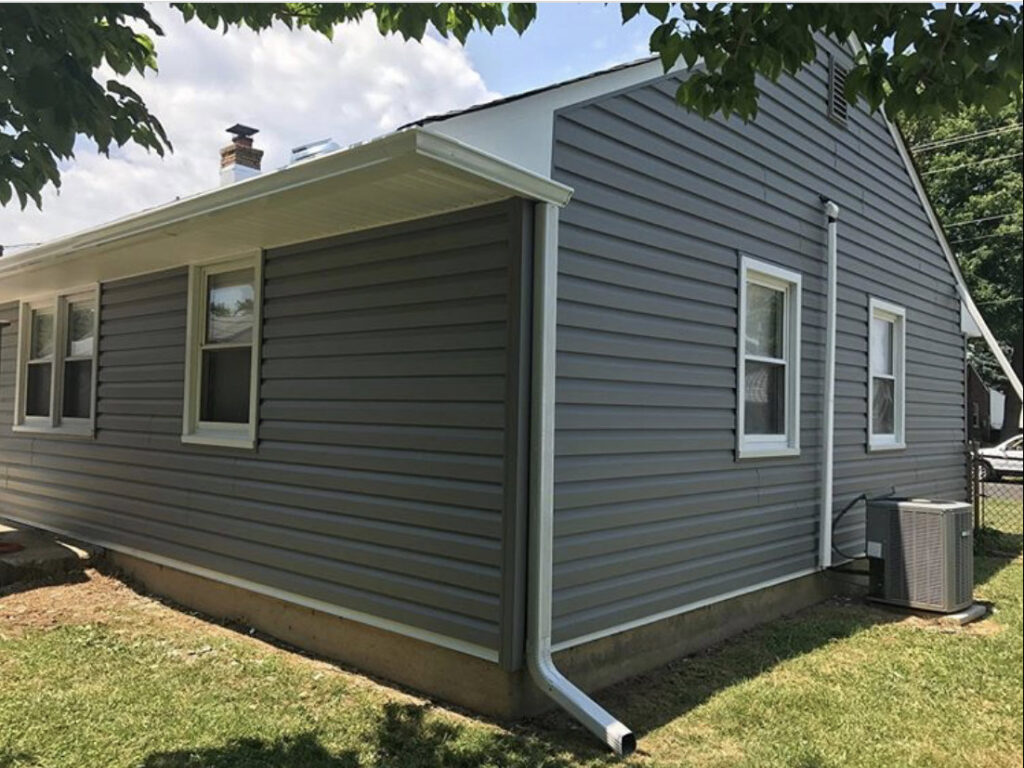 A completed house exterior with new grey vinyl siding and white gutters installed by S-G General Contracting LLC in Philadelphia, PA.