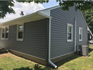 A completed house exterior with new grey vinyl siding and white gutters installed by S-G General Contracting LLC in Philadelphia, PA.