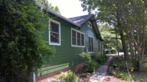 A completed house siding project with green panels and a landscaped pathway by Randolph Residential Repair in Durham, NC.