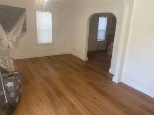A bright interior room with newly installed laminate flooring and freshly painted white walls by Knutson's Property Maintenance Llc in Williston, ND.