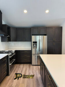 A completed kitchen remodel featuring dark cabinets, stainless steel appliances, and a white island by JP. Remodel Service LLC in Everett, WA.