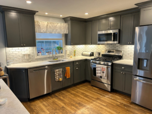 A beautifully completed kitchen remodel featuring gray cabinets and stainless steel appliances by Caldwell Construction in Richardson, TX
