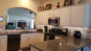 A beautifully completed kitchen remodel featuring white cabinets and new backsplash by T-Byrd Painting in Austin, TX