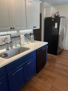 A beautifully completed kitchen renovation featuring blue lower cabinets and a new backsplash by Ricos Renovations in Arlington, TX