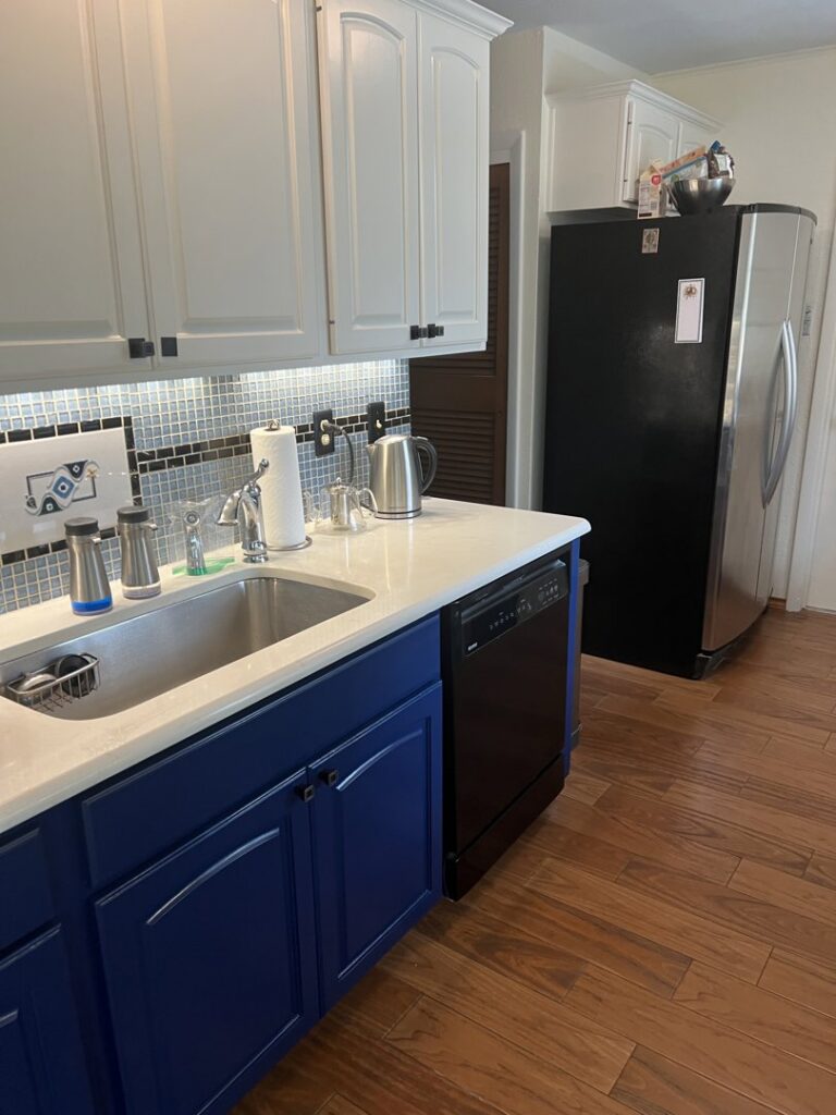 A beautifully completed kitchen renovation featuring blue lower cabinets and a new backsplash by Ricos Renovations in Arlington, TX