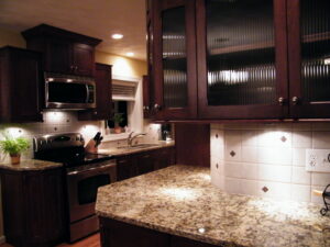 A beautifully completed kitchen renovation with dark cabinets and granite countertops by Pro Helping Hands Renovation in Colorado Springs, CO.